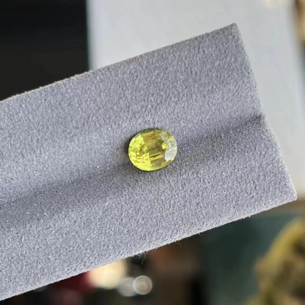 A sparkling 1.55-carat cushion-cut Chrysoberyl, an Indian specialty gemstone, known for its vibrant yellow-green color.