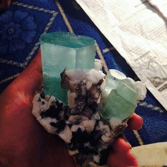 Close-up photo of an aquamarine crystal, a pale blue variety of the beryl mineral, showing its characteristic hexagonal structure.