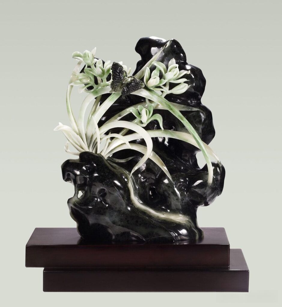A Black Dushan Jade ornament (Hei Du Yu) carved into a magnolia flower, listed by Boguan Auction.