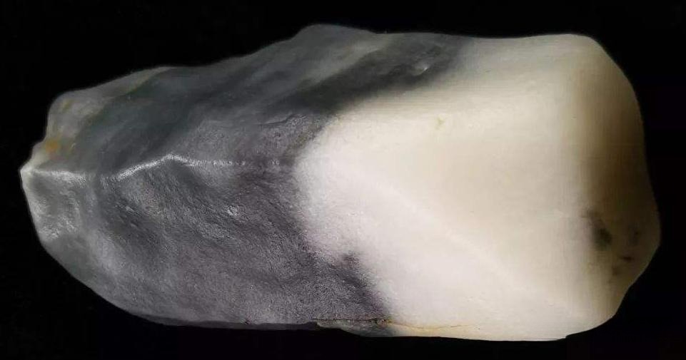 Black and white Jinsi Jade rough stone, a common look-alike for Hetian Jade 'Qinghua' material.