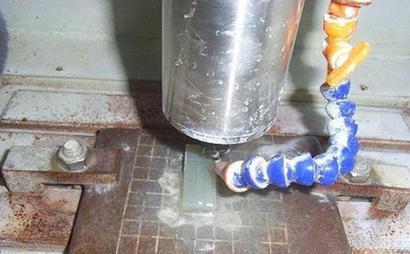 Machine carving jade using computer-guided engraving based on a digital design for precise detailing.