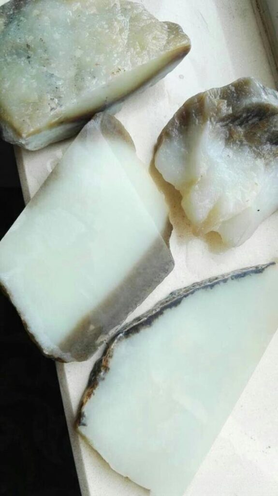 De-blackened Hetian jade material, showing artificially treated jade with dark spots removed to imitate higher-quality white jade.