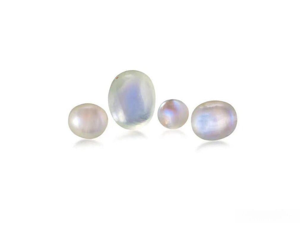 Four colorless, oval-cut Orthoclase Moonstones totaling 83.3 carats, all originating from India and displaying adularescence.