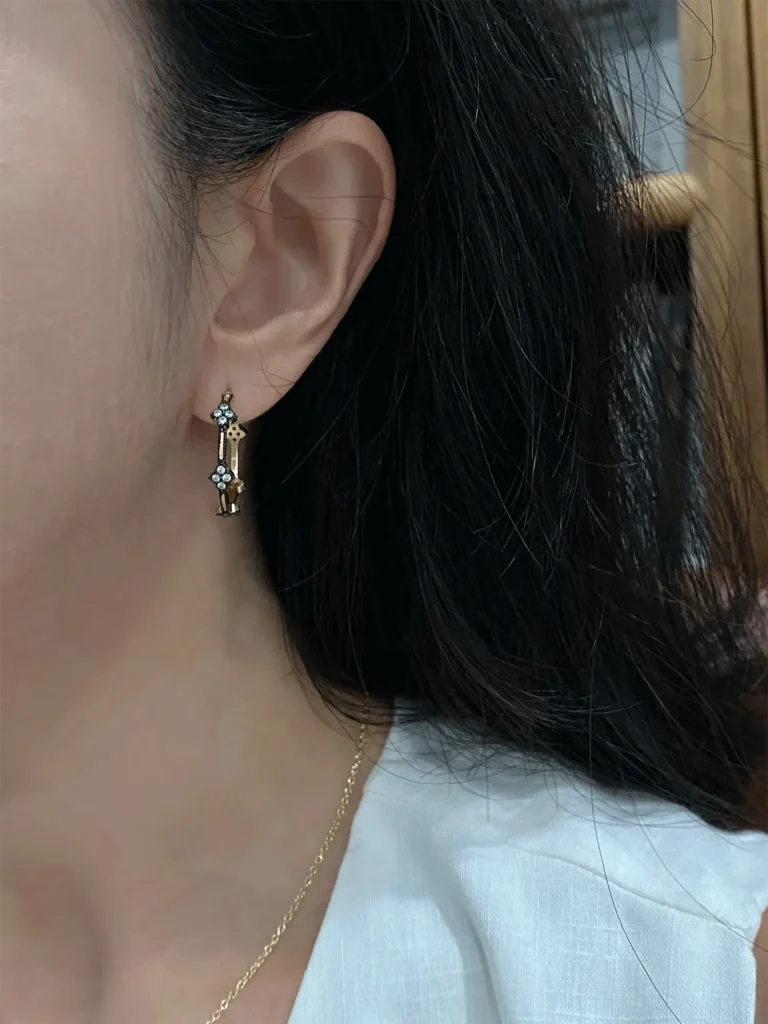 Gold-plated silver hoop earrings worn under natural light, showcasing their shine and elegance.