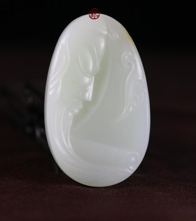 Hand-carved Guan Gong jade pendant showcasing intricate craftsmanship and traditional artistic details.