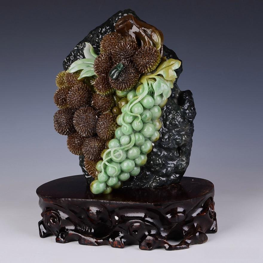A Dushan Jade carving displaying a multi-color blend of white, green, yellow, brown, and black hues within the same piece.