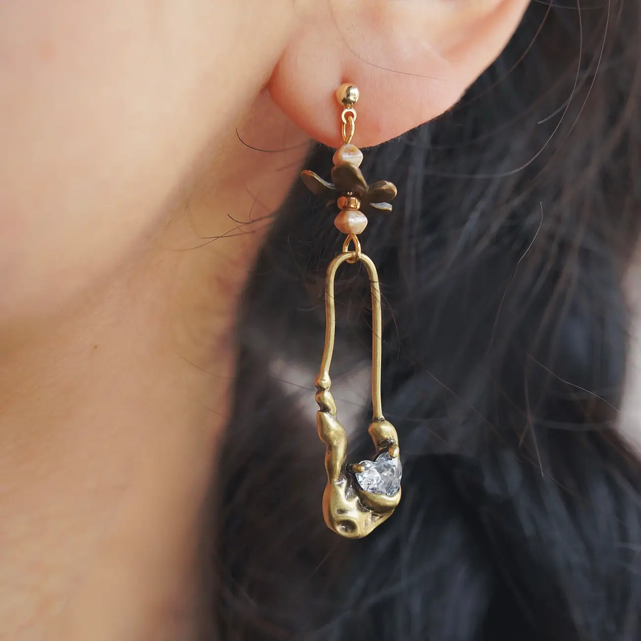 Peonyjewels handcrafted floral earrings worn on a model, showcasing daytime elegance.