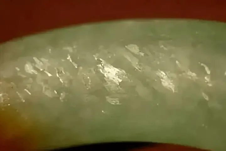 Peonyjewels jadeite bangle magnified view, highlighting flywing texture in white granular stone areas