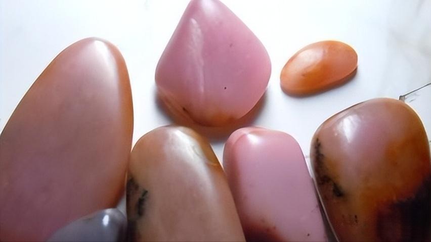Pink actinolite stone, commercially sold as "Peach Blossom Jade" or "Violet Jade," which mimics the appearance of certain shades of high-grade Hetian Jade.