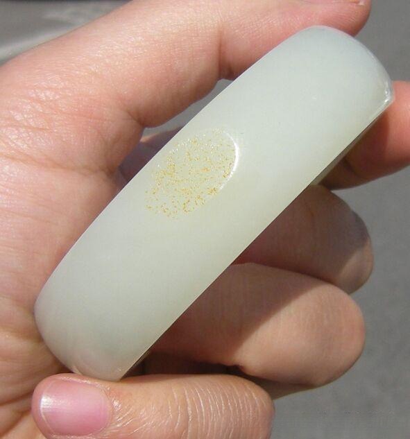 Poorly made fake de-blackened Hetian jade bracelet, showing low craftsmanship and artificial color treatment.