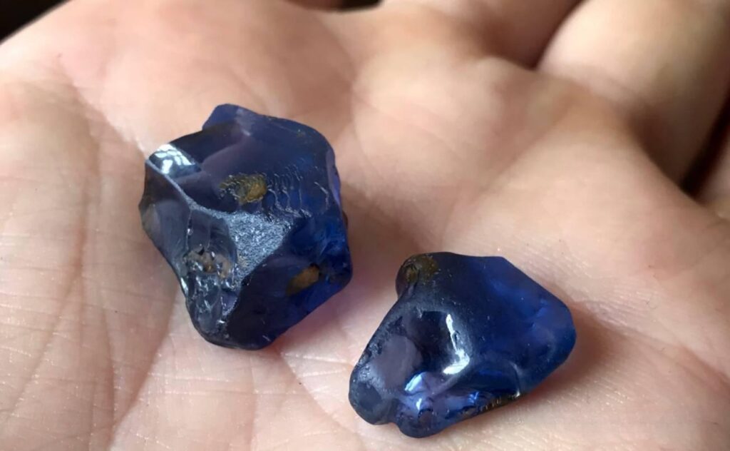Two Madagascar sapphires displayed in hand, showcasing their large size and vibrant color, highlighting Madagascar's significant contribution to global sapphire production.