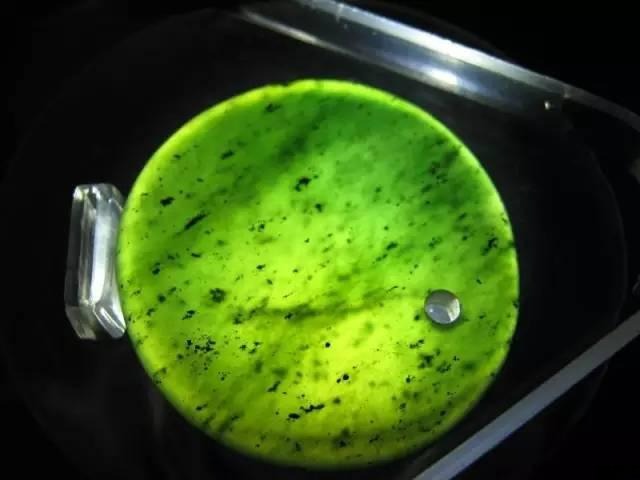 Magnified view of a Taishan Jade specimen, clearly showing natural white and black inclusions, typical of its serpentinite composition.