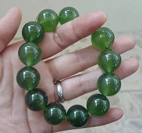 A strand of Taishan Jade (Serpentinite) beads, showcasing the stone's characteristic dark green and black hues.