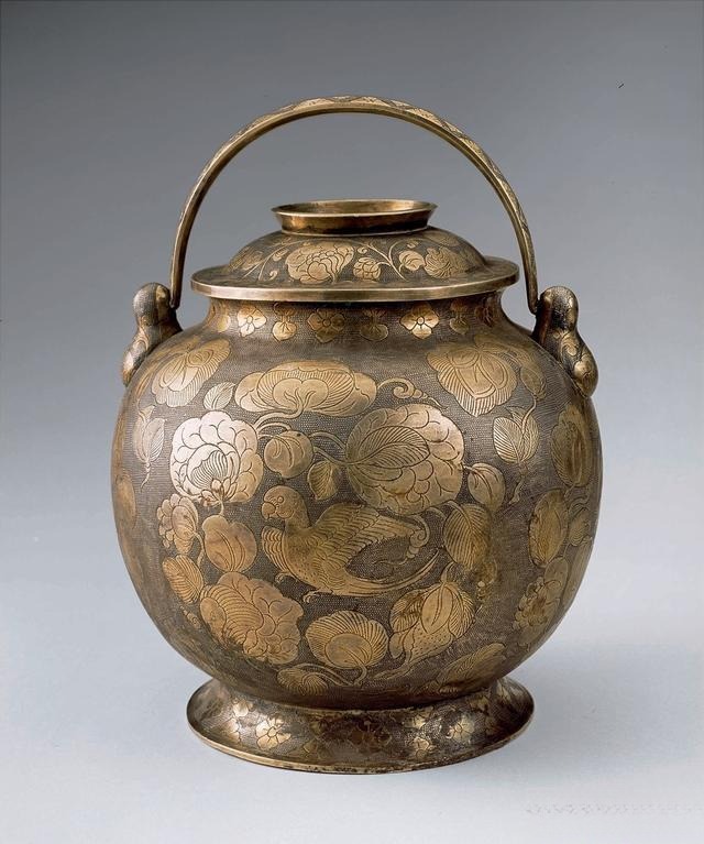Tang Dynasty gilded silver jar featuring a parrot motif and handle, showcasing traditional Chinese metalwork and gilding techniques