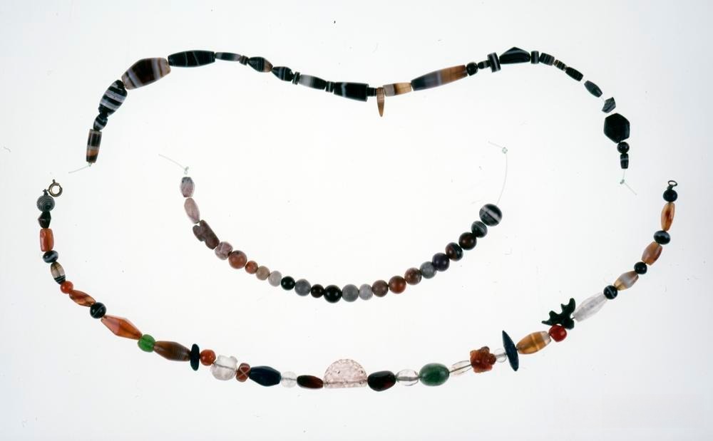 A variety of beaded jewelry featuring quartz, crystal, agate, and garnet, showcasing intricate designs and vibrant colors.