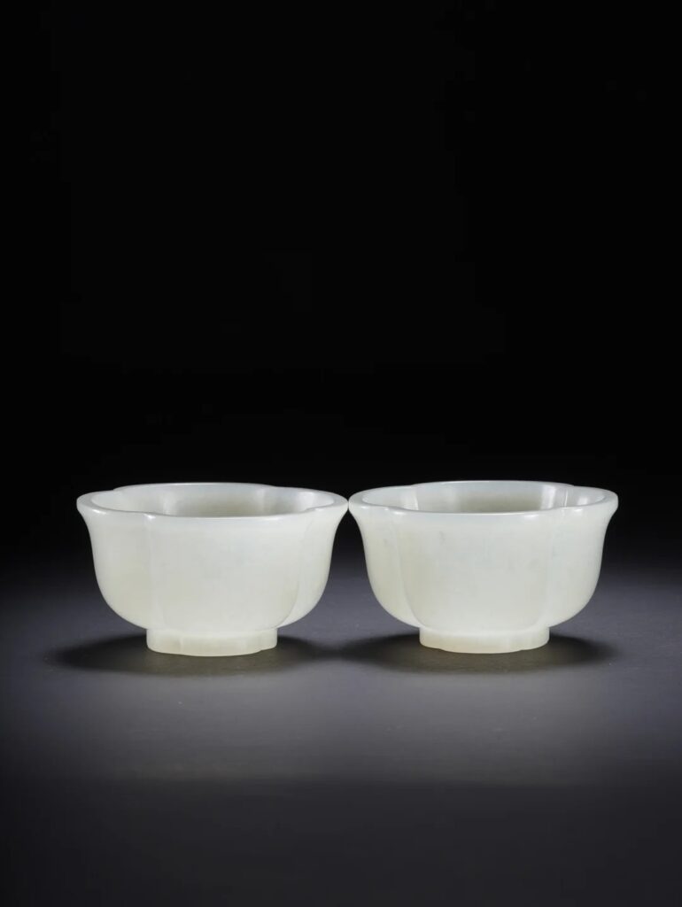A pair of white Hetian Jade cups with lobed rims, adorned with fine gold (gilt) painted decorative patterns.