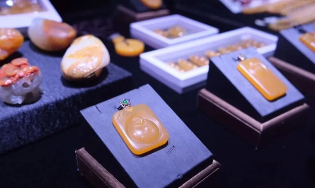 Yellow Dragon Jade jewelry pieces displayed on a counter under warm lighting, highlighting their golden translucence.