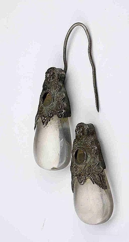 An ancient Chinese crystal artifact: Yuan Dynasty cut crystal earrings, precisely carved and finely polished to a mirror-like smoothness, reflecting exquisite craftsmanship.