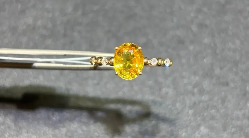 A 18K gold ring featuring a four-prong set yellow sapphire with brilliant diamond-like luster.