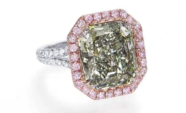 The 8.04ct Fancy Dark Gray-Green ring, framed by pink secondary stones.