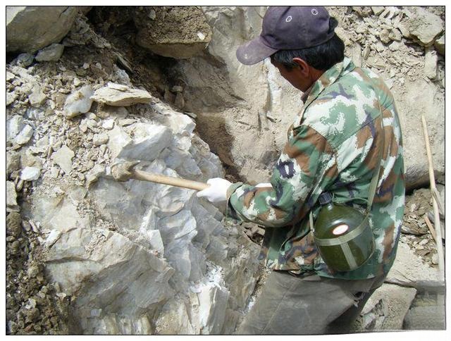 Miners extracting raw Hetian jade on steep, rugged Kunlun Mountain slopes.