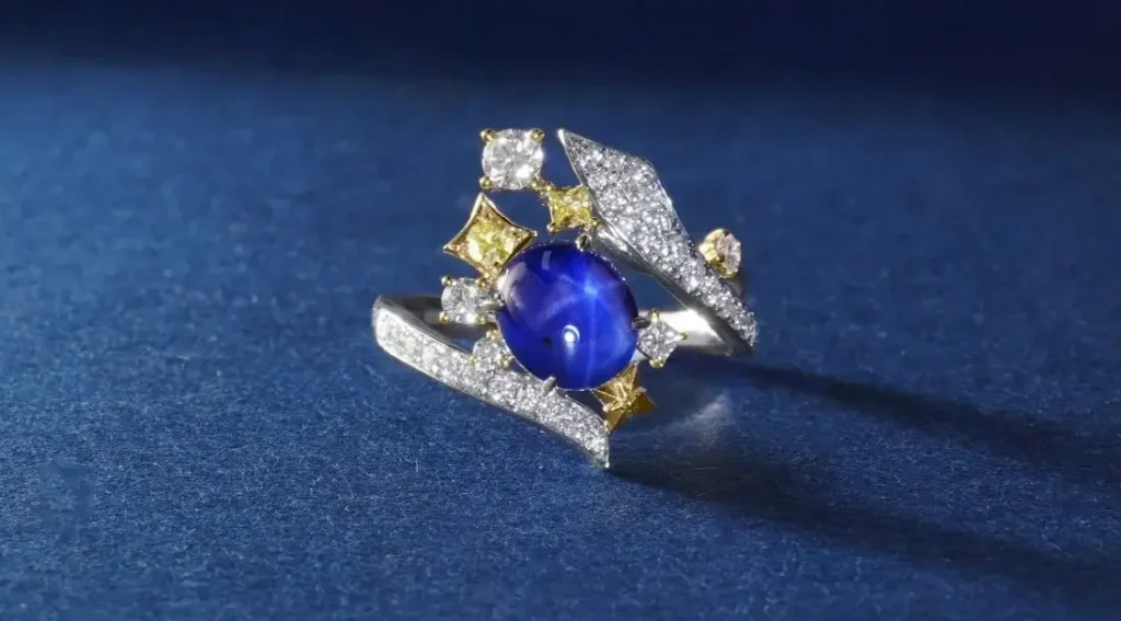 A custom Peony Jewels ring featuring a large, vibrant star(fancy colored) sapphire cabochon set in a modern, bespoke design.