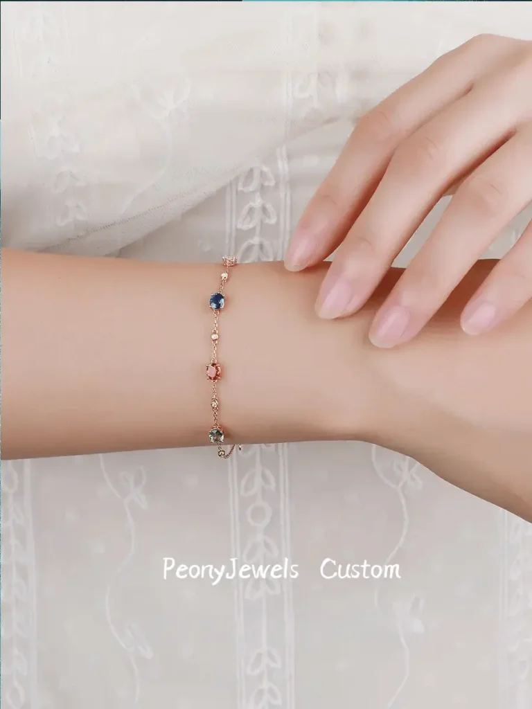 Custom Peony Jewels chain bracelet featuring multi-colored sapphires and diamonds set in yellow gold.