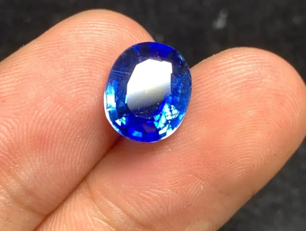 PeonyJewels handheld high-quality faceted gemstone showing subtle natural color banding and deep saturation.