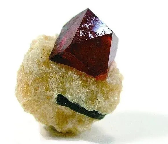 A raw red quartz crystal specimen with a deep crimson color and visible natural facets.
