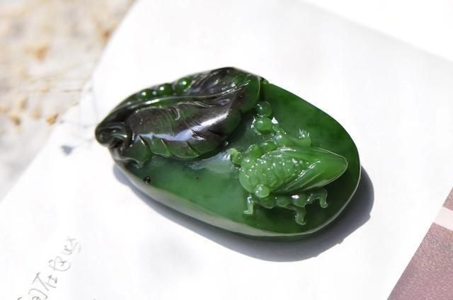 Russian Nephrite carving integrating natural black patches into artistic design.