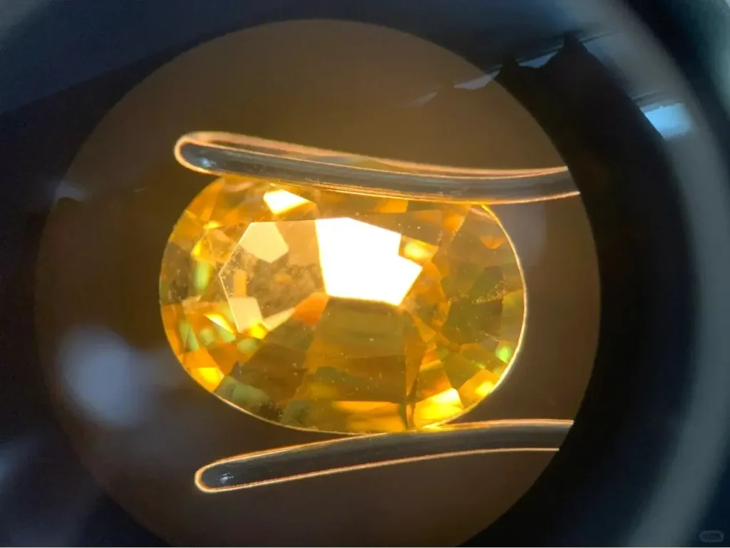 Microscopic view of a flame-fusion synthetic yellow sapphire showing an unnaturally clean interior without inclusions.