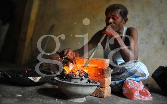 Traditional Sri Lankan miners using blowpipes and charcoal fires for gemstone treatments and enhancements.
