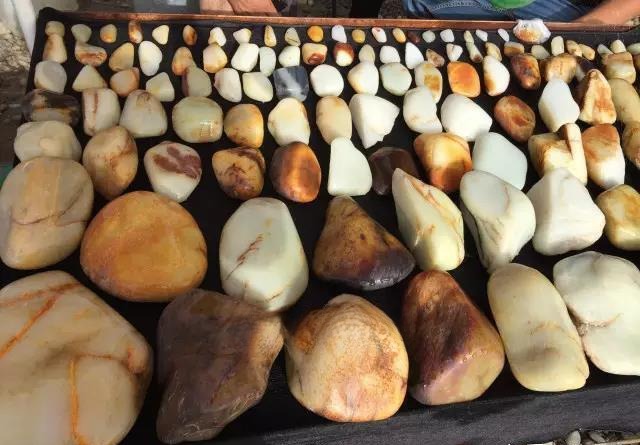Display of diverse Xinjiang Hetian Ziyu stones, showcasing the wide range of colors, skins, and ages found in the Yulongkashi River.