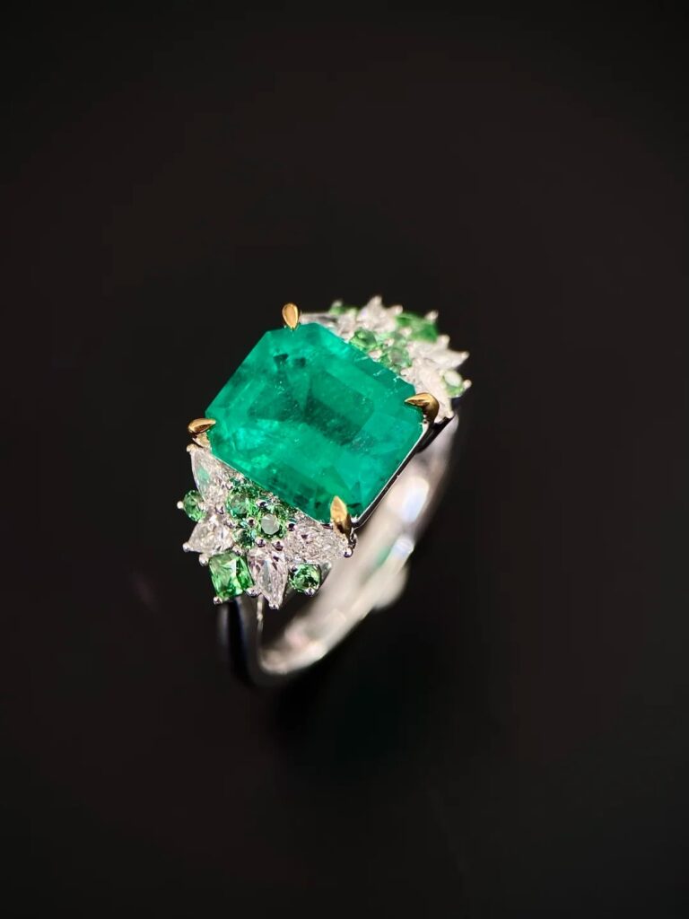 Colombian gemstones: 3ct Muzo emerald ring in 18k gold with diamond and tsavorite accents.