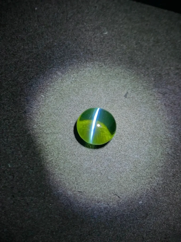 4-carat Chrysoberyl gemstone with a greenish hue, showing natural chatoyancy and high-quality characteristics.
