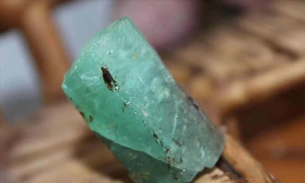 Green Brazilian emerald crystals embedded in mica schist and pegmatite host rock matrix.