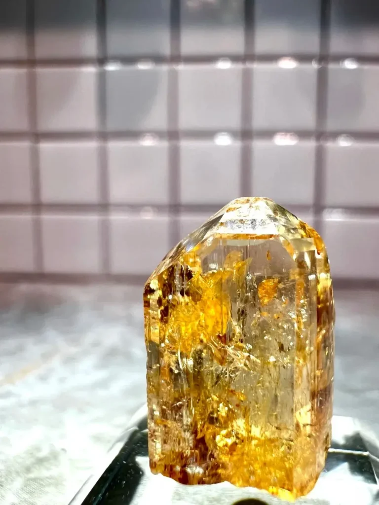 A vivid pink-orange Imperial Topaz gemstone with exceptional clarity and rich saturation.