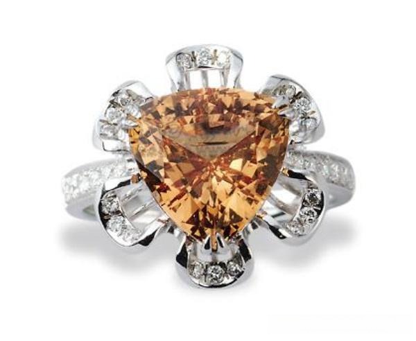 4.25-carat faceted golden-orange gemstone set in an 18K yellow gold diamond ring mounting.