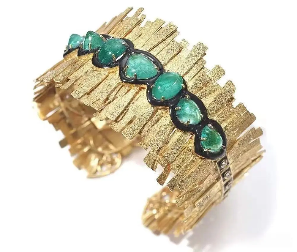 Luxury Coomi bracelet featuring 12.93 carats of vibrant Muzo emeralds set in textured 20k gold.