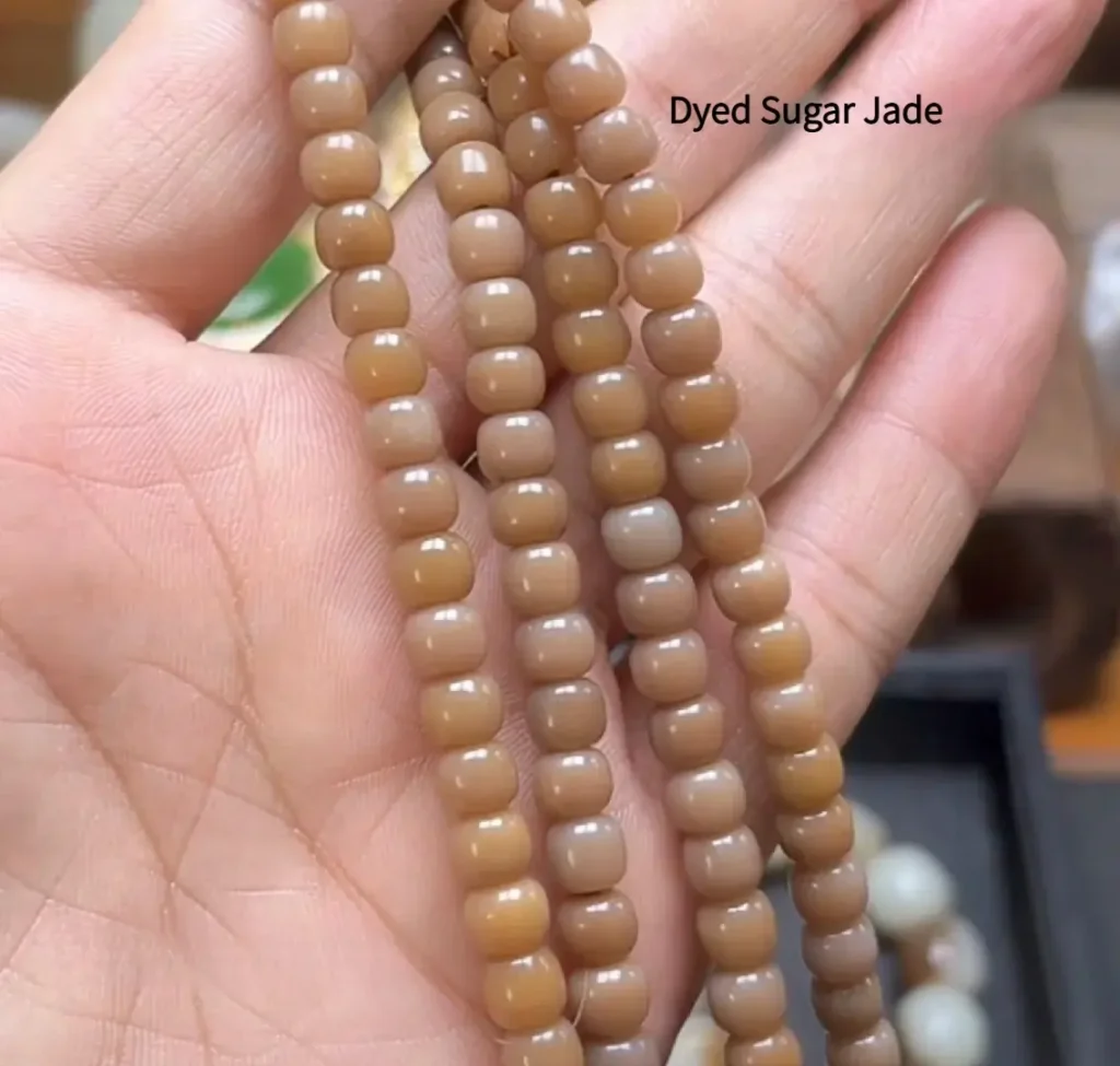 Dyed Hetian jade beads showing patchy and superficial color distribution.