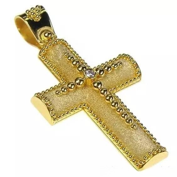 A gold cross pendant decorated with intricate handcrafted granulation patterns.