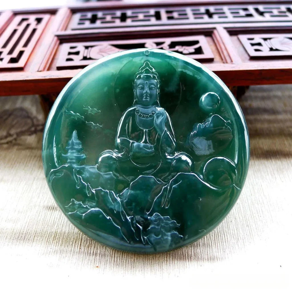 A carved translucent blue-gray jadeite Guanyin pendant with a fine, oily polished surface.