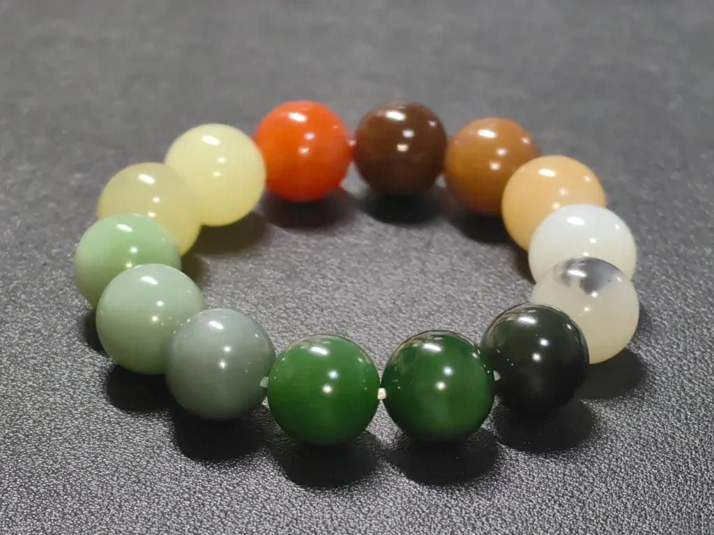 A multi-colored Hetian jade bead bracelet featuring white, green, sugar, and ink jade beads.