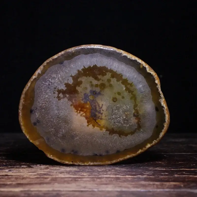 A polished slice of natural Brazilian agate showing concentric circular bands and translucent layers.