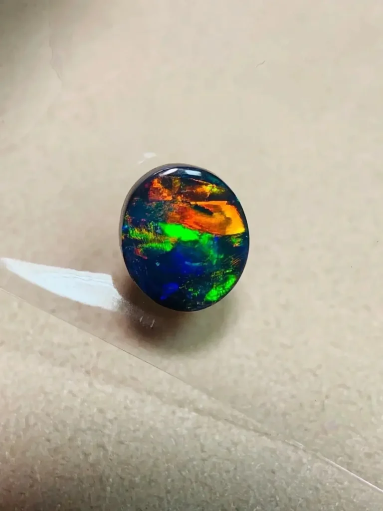 Natural Lightning Ridge Black Opal with dark N1 body tone and electric blue-green play-of-color.