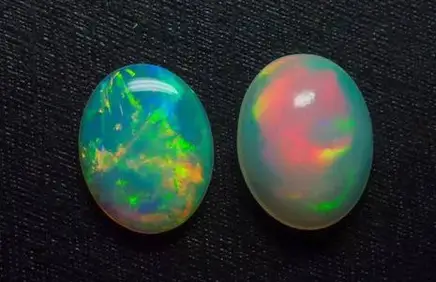 Side-by-side comparison of a commercial white opal and a high-end investment-grade Australian Black Opal with intense red fire.