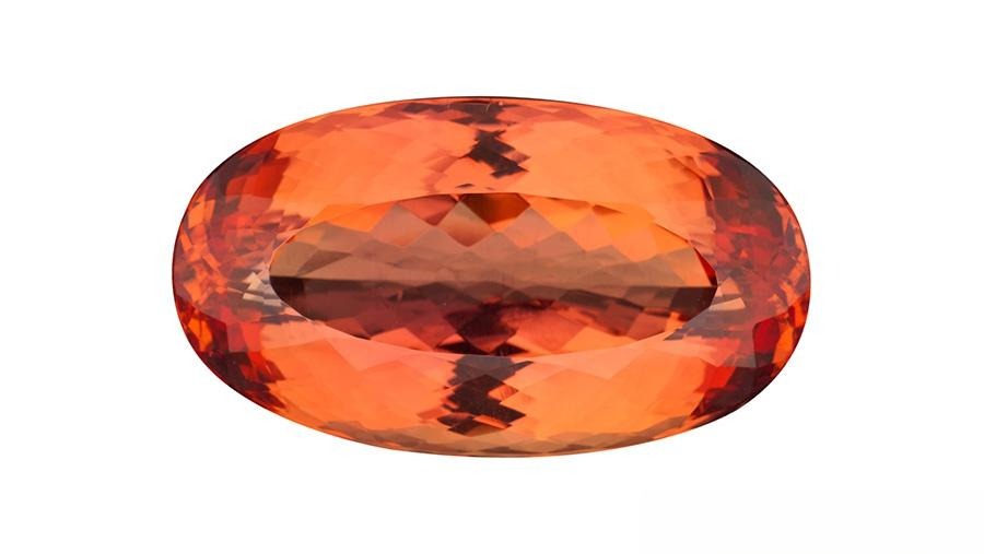Oval-cut Imperial Topaz with rare reddish-orange hues, symbolizing its historical royal heritage.
