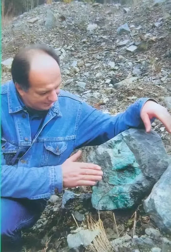A Russian jadeite merchant handling raw jadeite stones, showing natural green color and texture.