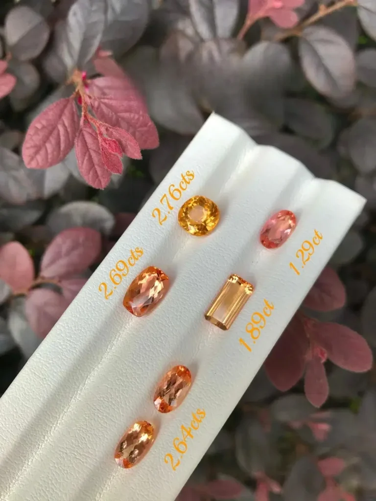 Group of Sherry-colored gems in various carat weights, showcasing the warm pink-orange color spectrum.