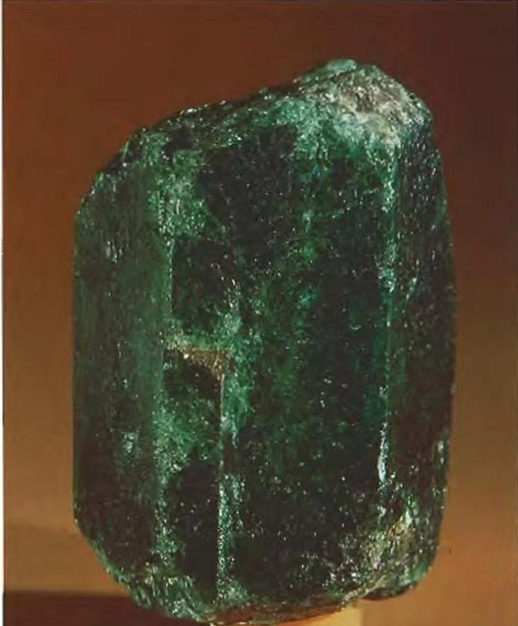 Single-crystal emerald from the Ural Mountains, showing natural hexagonal form and green coloration.